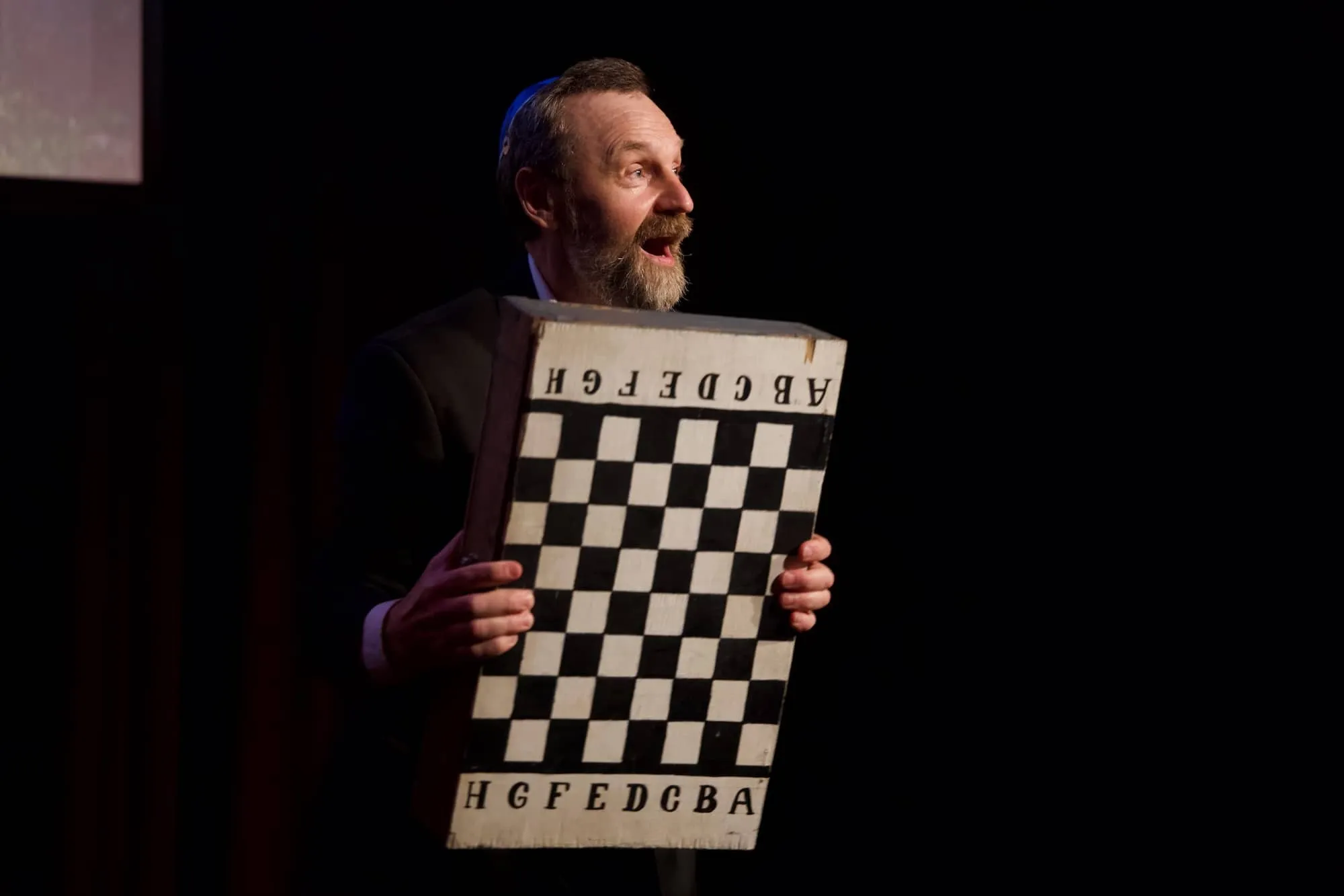 Artist with a chess bard on the stage of Tallinn Fringe Festival 2026