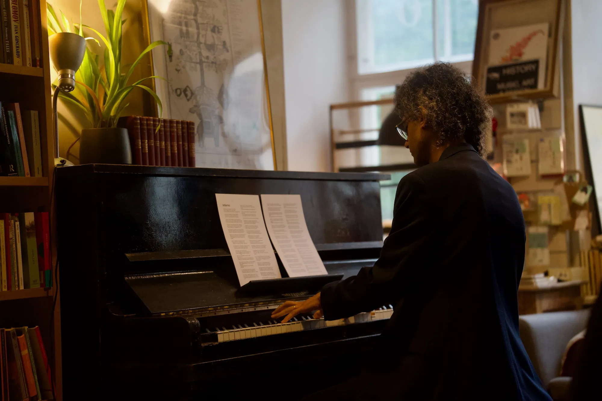 Pianist performing on an acoustic upright piano in a bookshop. Tallinn Fringe Festival 2026